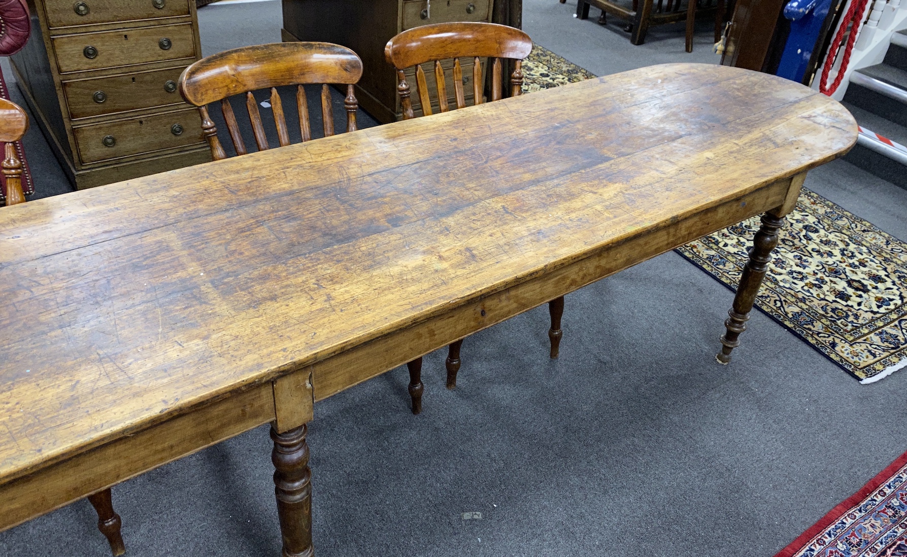 A 19th century French elm and fruitwood farmhouse table the triple planked top on six turned tapered legs, length 370cm, depth 67cm, height 73cm